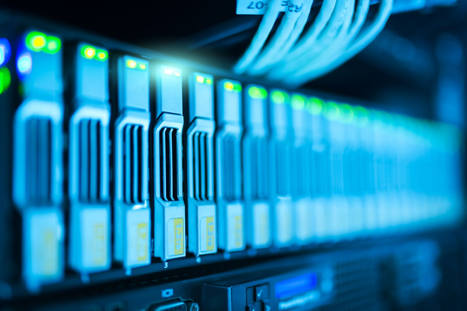 Server blades and network cabling lit blue inside a rack